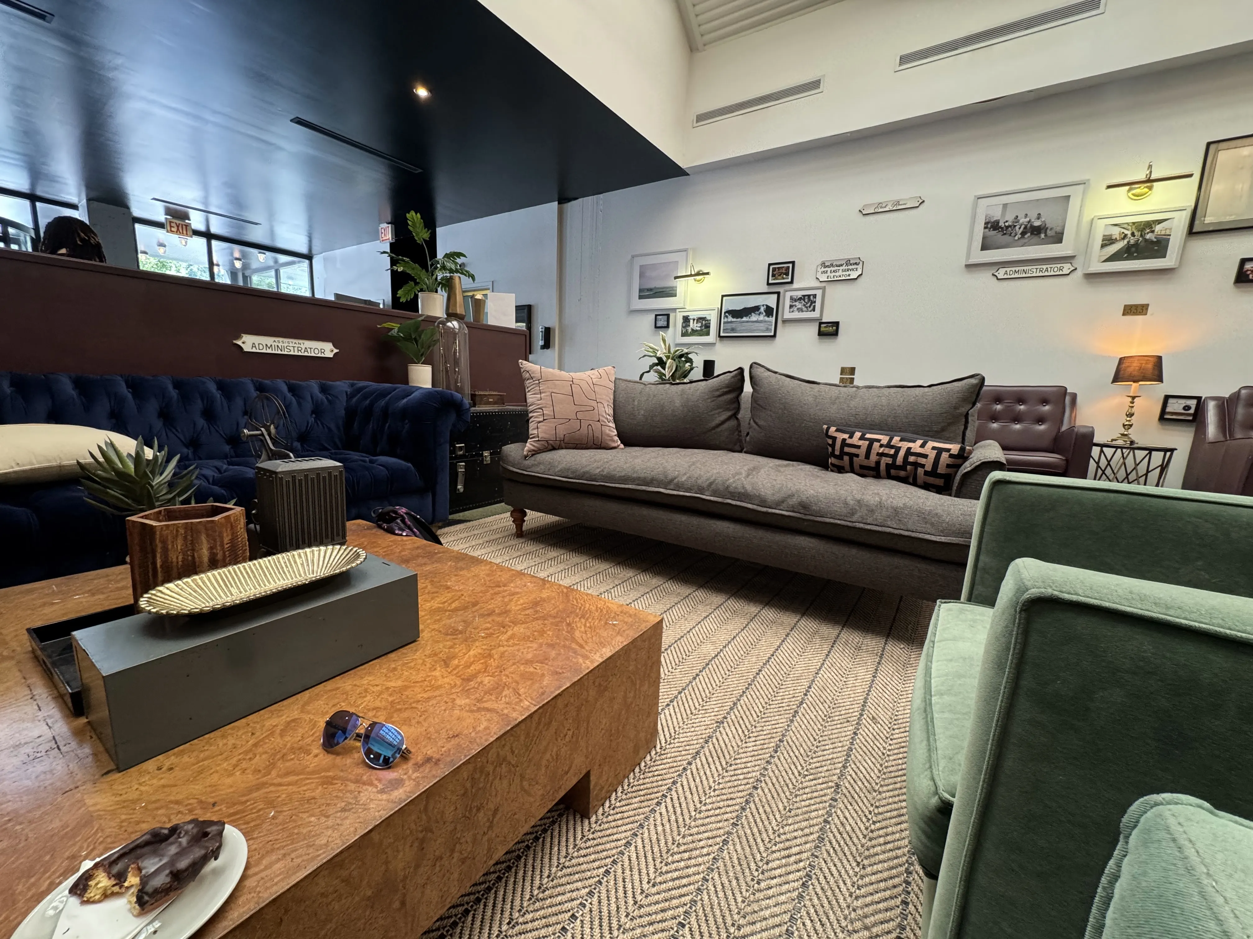 Lobby area from another angle, showcasing two varied couches, some armchairs, and a large low-set coffee table
