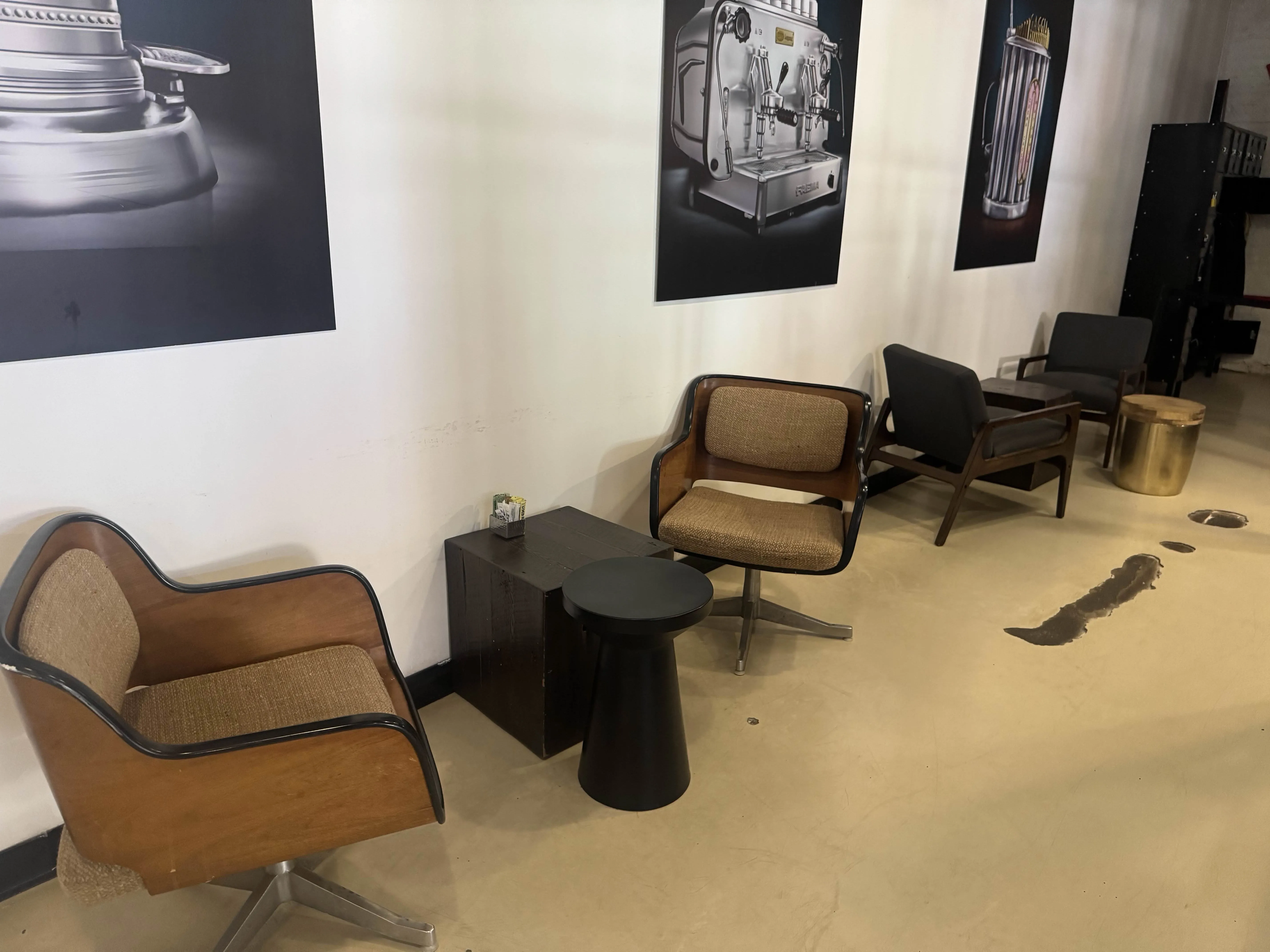 A few armchairs at the back wall, with small tables between them