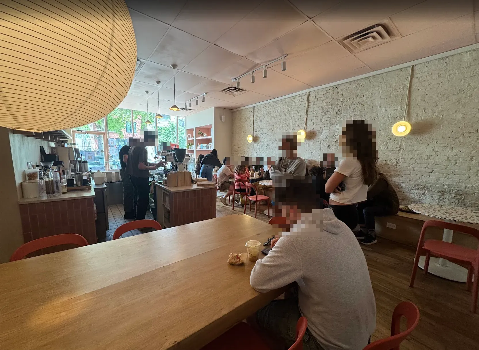 View of Allez Cafe from the back, showing the service counter on the left, and the smaller cafe tables on the right.