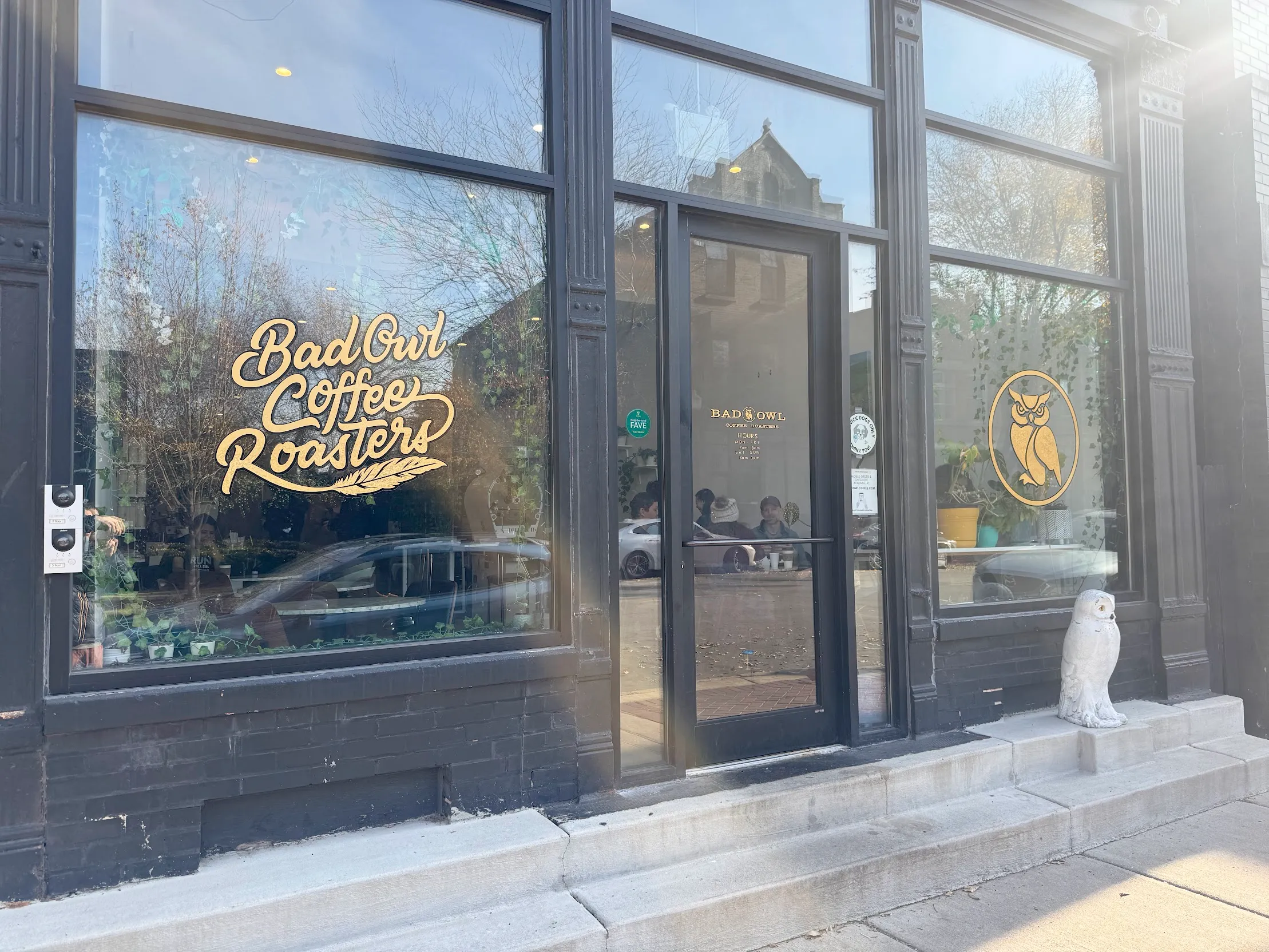Cafe entrance. Full glass panes with gold text reading the name of the shop