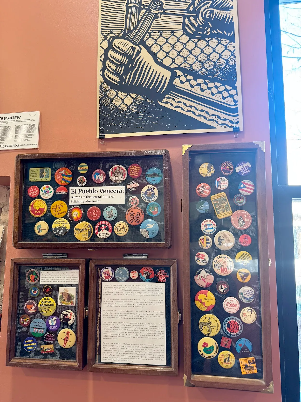 Orange wall featuring anticolonial posters and political buttons