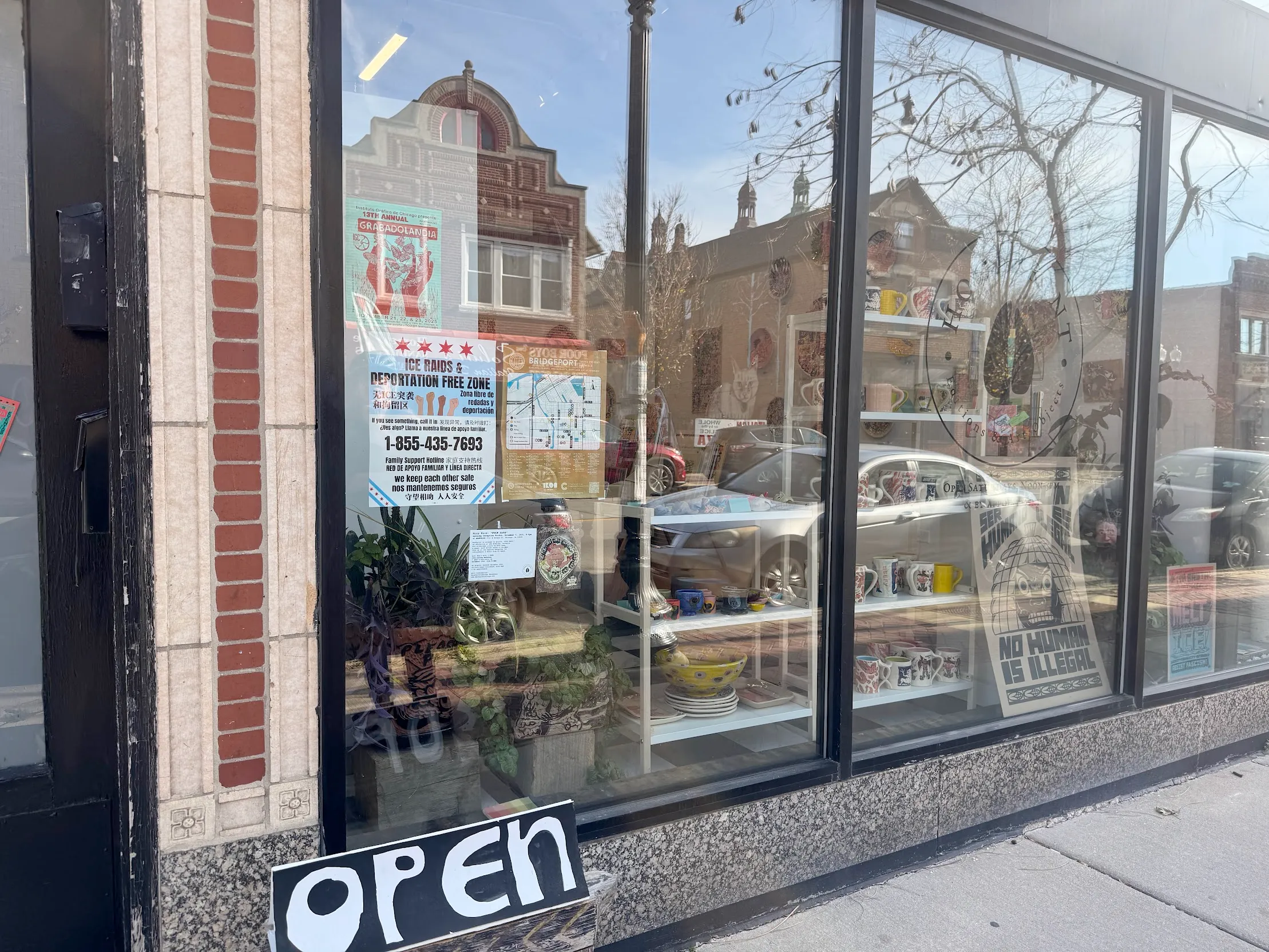A reflective glass storefront to a local art gallery and print shop