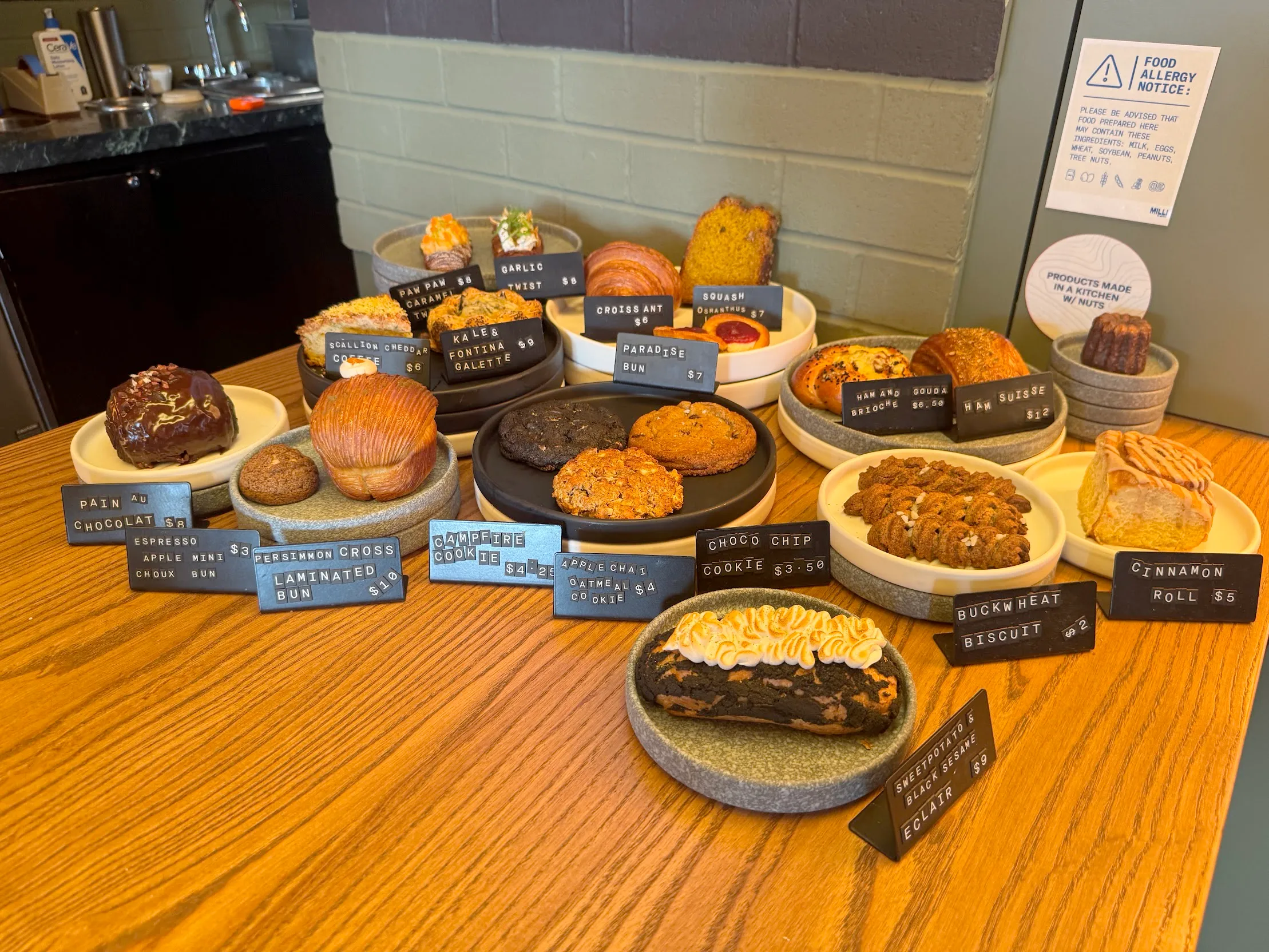 Collection of fresh pastries with prices on placards in front