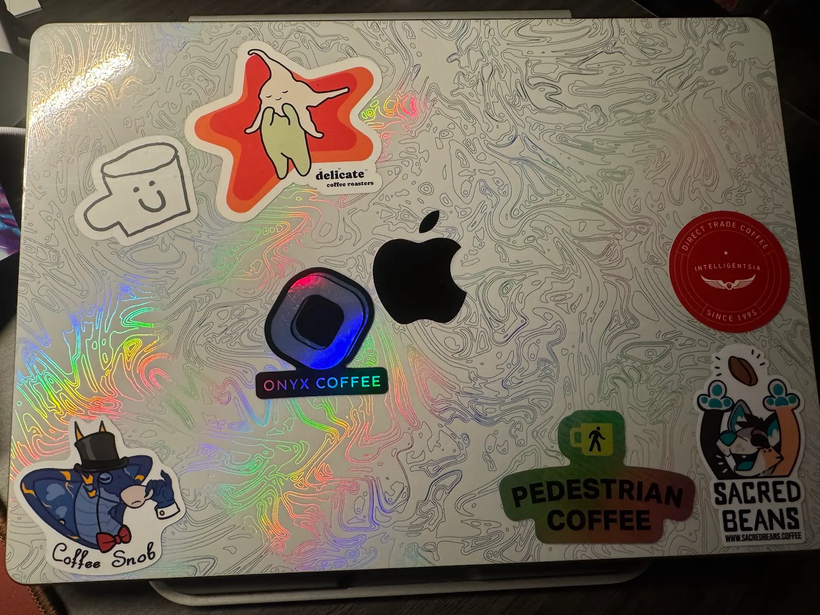 Photo of my macbook with a custom skin and a bunch of coffee related stickers on it