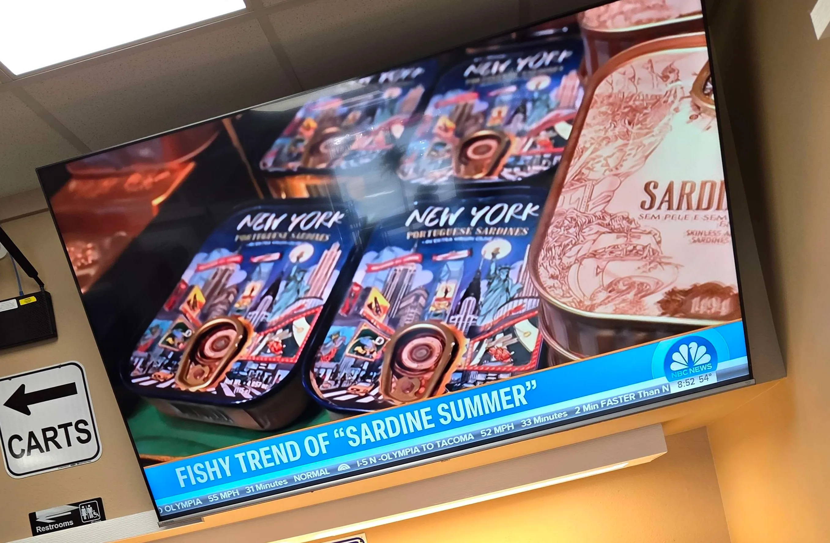 Crooked photo of a TV displaying a "news" story about "Sardine Summer"